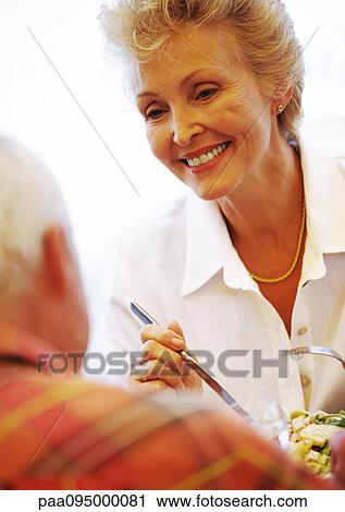 Stock Image - Mature woman smiling at mature man, close-up. Fotosearch