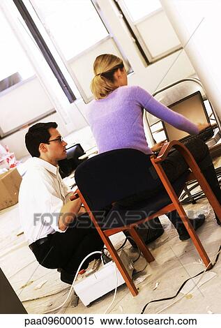 Man and woman working on laptop computer on chair View Large Photo Image Stock Photography - Man and woman working on laptop computer on chair. Fotosearch