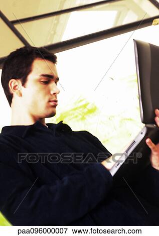Stock Photo - Man holding laptop computer. Fotosearch