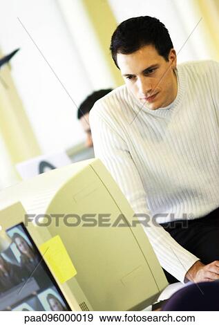 Man looking at computer monitor in office View Large Photo Image Stock Photo - Man looking at computer monitor in office. Fotosearch