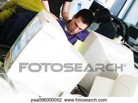 Stock Image - Man working at computer in office. Fotosearch