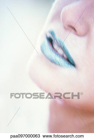 Stock Image - Woman wearing green lipstick, lower part of face, close-up. Fotosearch