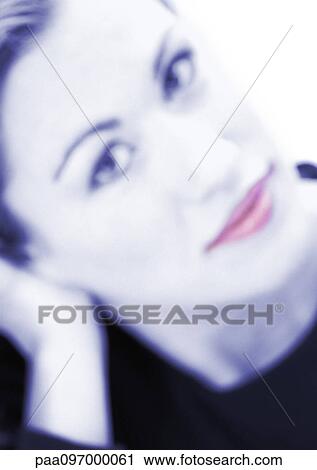Stock Image - Woman's face, looking at camera, close-up, portrait, blurred. Fotosearch