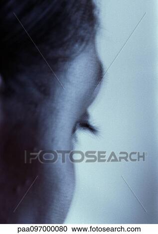 Stock Image - Woman's face, partial rear view, close-up. Fotosearch