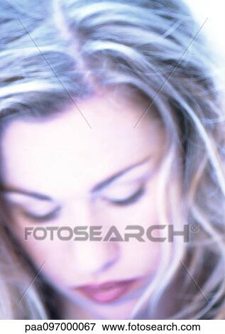 Stock Photo - Woman's face with lowered eyes, close-up, blurred. Fotosearch