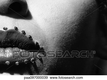 Stock Photo - Woman's lips with jewel adornments, partial view, close-up, B&W. Fotosearch