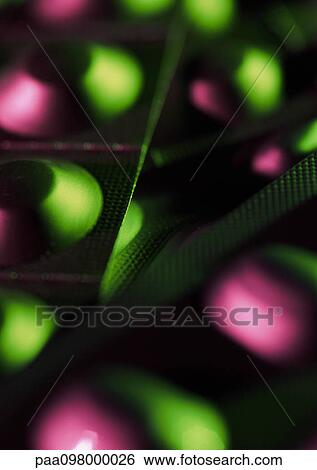 Stock Photograph - Packs of medicine tablets, close up, green and pink tones. Fotosearch