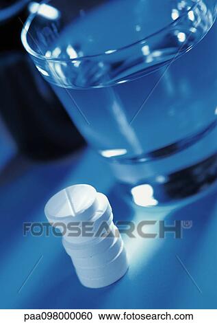 Pile of tablets and glass of water View Large Photo Image Stock Image - Pile of tablets and glass of water. Fotosearch