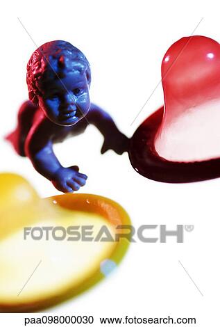 Plastic baby doll between condoms, close-up View Large Photo Image Stock Image - Plastic baby doll between condoms, close-up. Fotosearch
