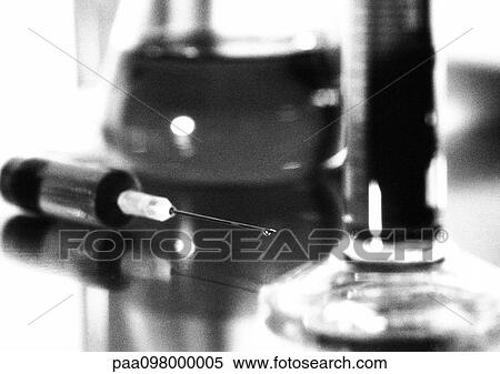 Stock Photography - Syringe and laboratory glassware, close-up, b&w. Fotosearch