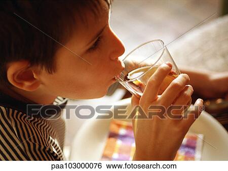 Stock Photograph - Child drinking, side view, close-up. Fotosearch