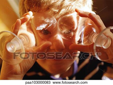 Child holding wine glasses in front of eyes, portrait View Large Photo Image Stock Image - Child holding wine glasses in front of eyes, portrait. Fotosearch