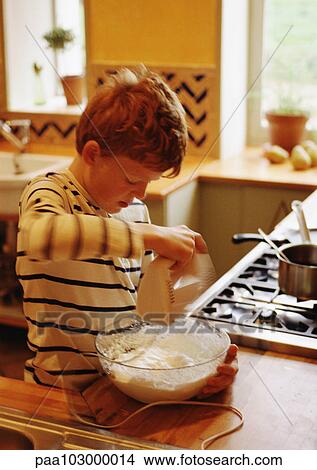 Child standing in kitchen, mixing batter with electric mixer, blurred motion View Large Photo Image Picture - Child standing in kitchen, mixing batter with electric mixer, blurred motion. Fotosearch