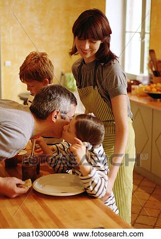 Family in kitchen, child kissing father on cheek View Large Photo Image Stock Photo - Family in kitchen, child kissing father on cheek. Fotosearch