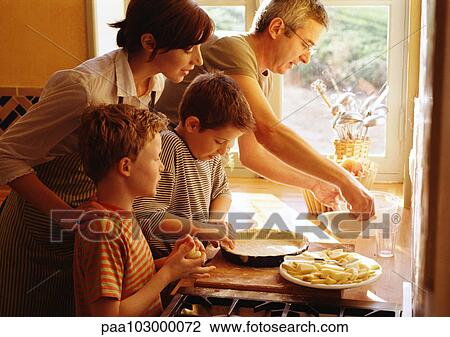 Stock Image - Family preparing a pie. Fotosearch