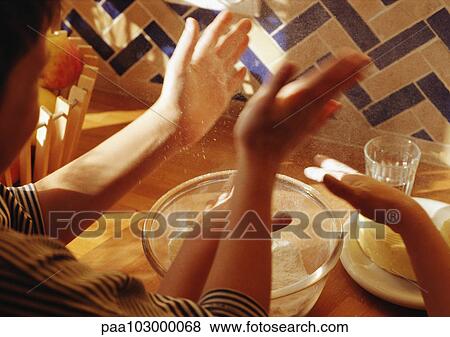 Stock Photo - Hands above bowl with flour. Fotosearch