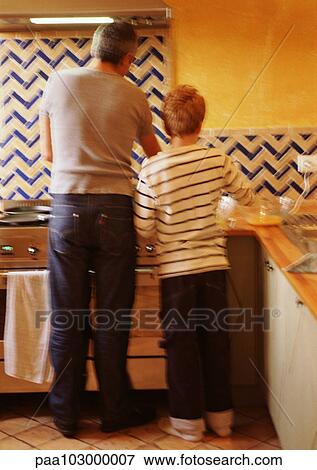 Man and child standing in kitchen, rear view View Large Photo Image Stock Photo - Man and child standing in kitchen, rear view. Fotosearch