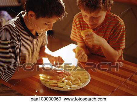 One child placing apple slices on plate, second child holding lemon halves View Large Photo Image Stock Photo - One child placing apple slices on plate, second child holding lemon halves. Fotosearch