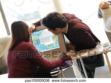 Man and woman looking at computer screen View Large Photo Image Stock Photograph - Man and woman looking at computer screen. Fotosearch