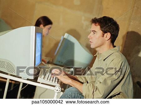 Man and woman working on computers View Large Photo Image Stock Image - Man and woman working on computers. Fotosearch