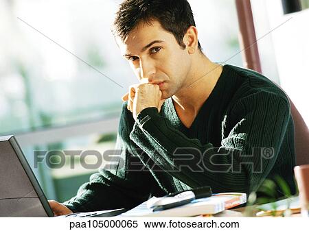 Stock Photography - Man sitting at computer, portrait. Fotosearch