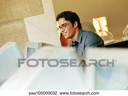 Man using computer, smiling View Large Photo Image Stock Image - Man using computer, smiling. Fotosearch