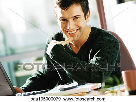 Man with hand on laptop computer, smiling, portrait View Large Photo Image Stock Photo - Man with hand on laptop computer, smiling, portrait. Fotosearch
