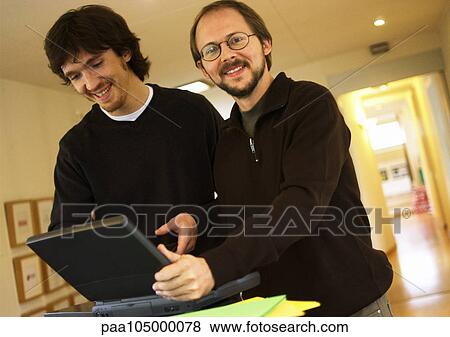 Two men with laptop computer, smiling View Large Photo Image Stock Photo - Two men with laptop computer, smiling. Fotosearch