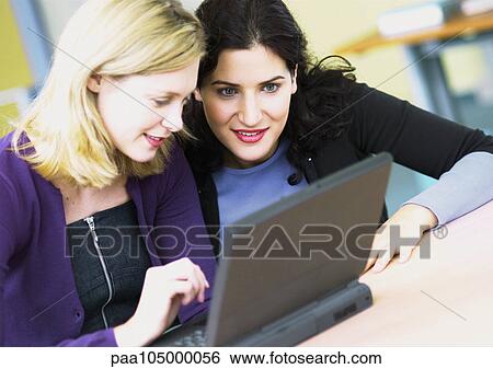 Two women using laptop computer View Large Photo Image Stock Photograph - Two women using laptop computer. Fotosearch
