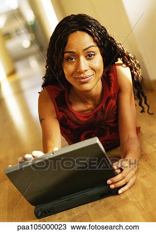 Woman lying on floor with laptop computer, portrait View Large Photo Image Stock Image - Woman lying on floor with laptop computer, portrait. Fotosearch
