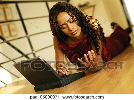 Woman lying on floor with laptop computer View Large Photo Image Stock Image - Woman lying on floor with laptop computer. Fotosearch