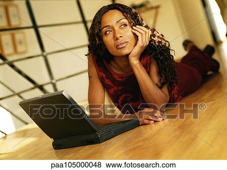 Woman lying on floor with laptop computer View Large Photo Image Stock Photo - Woman lying on floor with laptop computer. Fotosearch