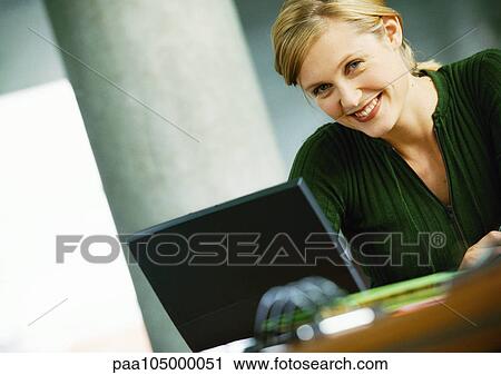 Woman with laptop computer, smiling, portrait View Large Photo Image Stock Image - Woman with laptop computer, smiling, portrait. Fotosearch
