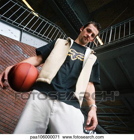 Young man holding basketball, low angle view View Large Photo Image Stock Image - Young man holding basketball, low angle view. Fotosearch