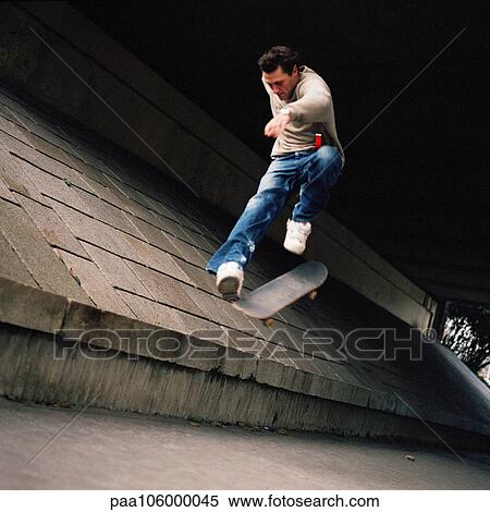Stock Photography - Young man in mid-air jump with skateboard. Fotosearch
