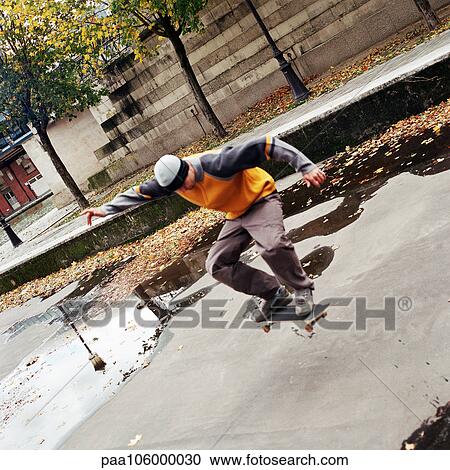 Young man in mid-air on skateboard View Large Photo Image Stock Image - Young man in mid-air on skateboard. Fotosearch