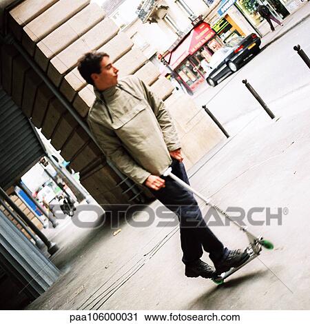 Young man on push scooter View Large Photo Image Stock Image - Young man on push scooter. Fotosearch