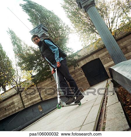 Stock Image - Young man on push scooter. Fotosearch