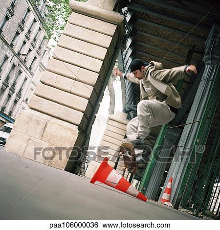 Stock Photograph - Young man performing skateboard trick. Fotosearch