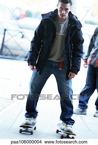 Young man riding two skateboards View Large Photo Image Picture - Young man riding two skateboards. Fotosearch