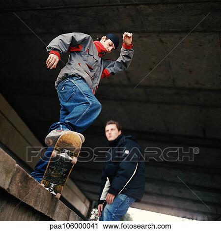 Young man skateboarding, low angle view View Large Photo Image Stock Image - Young man skateboarding, low angle view. Fotosearch