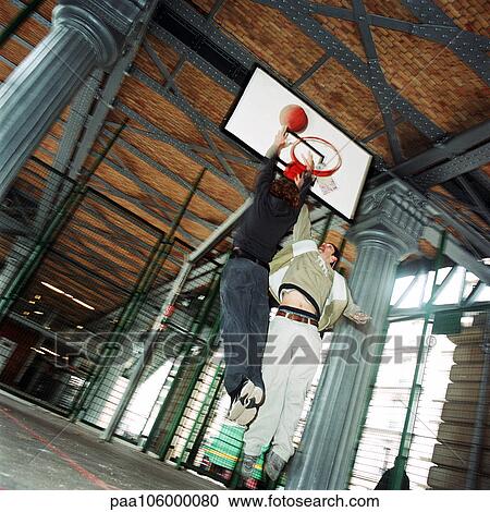 Young men in mid-air jump with basketball, blurred View Large Photo Image Stock Image - Young men in mid-air jump with basketball, blurred. Fotosearch