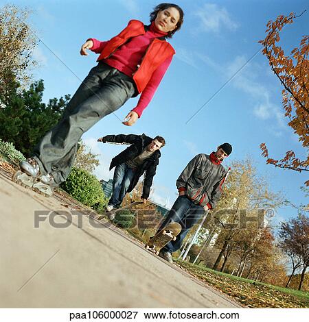 Young people in park, with inline skates and skateboards View Large Photo Image Stock Photo - Young people in park, with inline skates and skateboards. Fotosearch