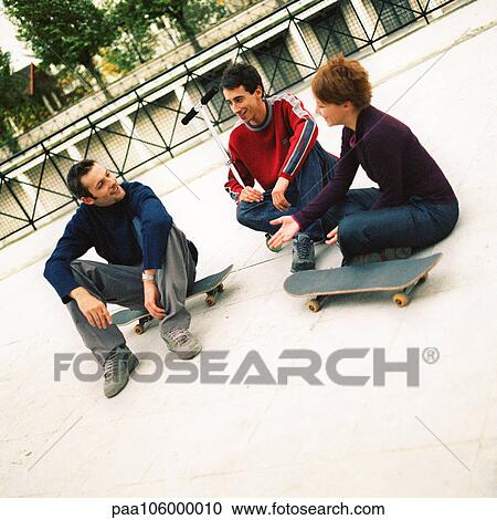 Young people sitting outdoors with skateboards View Large Photo Image Stock Image - Young people sitting outdoors with skateboards . Fotosearch