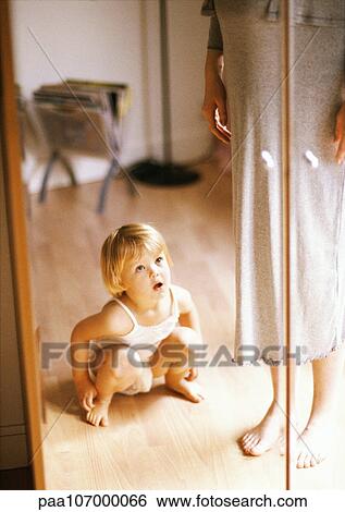 Child crouching in front of mirror beside pregnant woman View Large Photo Image Stock Photograph - Child crouching in front of mirror beside pregnant woman. Fotosearch