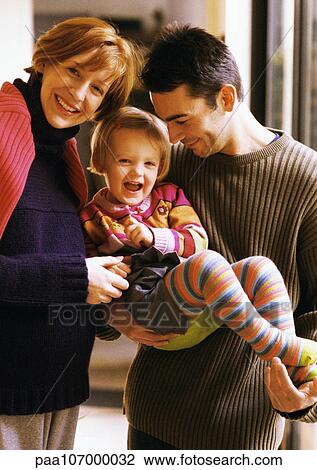 Couple holding child, smiling View Large Photo Image Stock Image - Couple holding child, smiling. Fotosearch