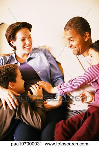 Couple sitting with children, smiling View Large Photo Image Stock Image - Couple sitting with children, smiling. Fotosearch