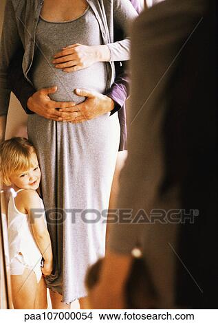Hands on pregnant woman's stomach, child standing next to woman View Large Photo Image Picture - Hands on pregnant woman's stomach, child standing next to woman. Fotosearch