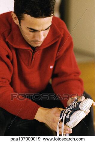 Stock Photo - Man looking at child's shoes. Fotosearch
