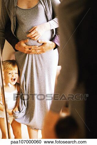 Pregnant woman and child in front of mirror, man's arms around woman's stomach View Large Photo Image Stock Image - Pregnant woman and child in front of mirror, man's arms around woman's stomach. Fotosearch